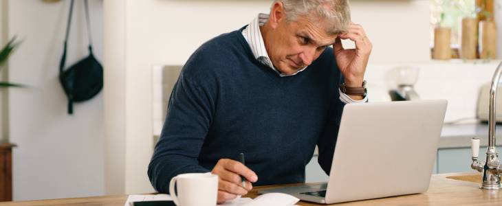 man looking distraught in front of laptop