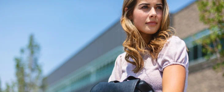 a college age female in front of school